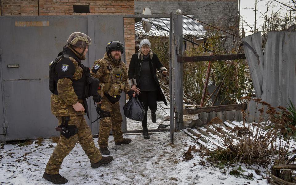 Enkele ’Witte Engelen’ helpen Svitlana (58) met de evacuatie uit haar huis in Bachmoet.