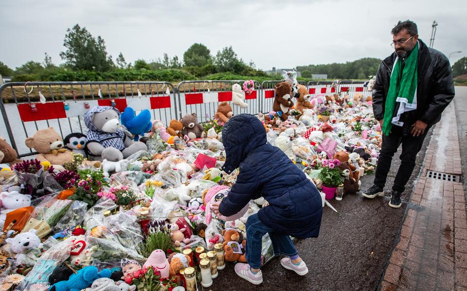 Een Syrisch kind legt een knuffel neer voor Jeffrey en Emma in Winschoten. 