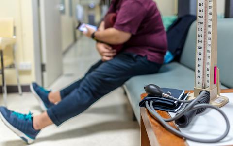 Een persoon met obesitas in de wachtkamer van een ziekenhuis.