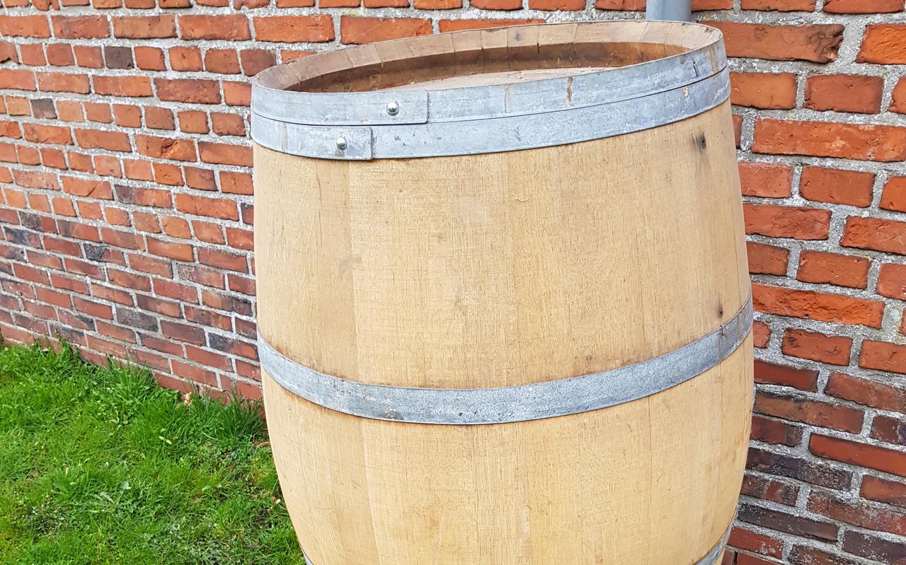 Een houten vat doet prima dienst als regenton.