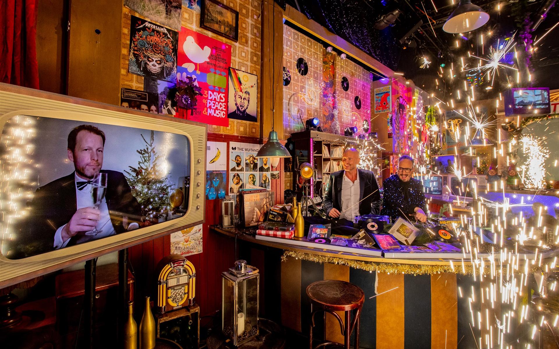 Herman van der Zandt en dj's Frank van ‘t Hof en Wouter van der Goes tijdens het NOS Nationaal Aftelmoment in het Top 2000 Cafe op oudejaarsavond 2021.
