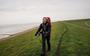 Carlien Bootsma loopt op de dijk langs de Waddenzee. „Van lopen kreeg ik het wel weer warm.”
