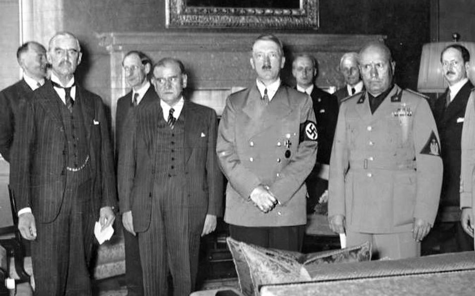 Adolf Hitler (met snor) is spekkoper op de Conferentie van München in 1938. In krijtpak geheel links Neville Chamberlain, naast hem Édouard Daladier. Rechts in uniform Benito Mussolini.