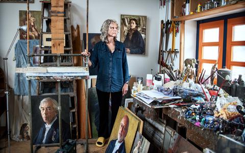 Dorine Kuiper, portretschilder tussen de portretten in haar atelier.