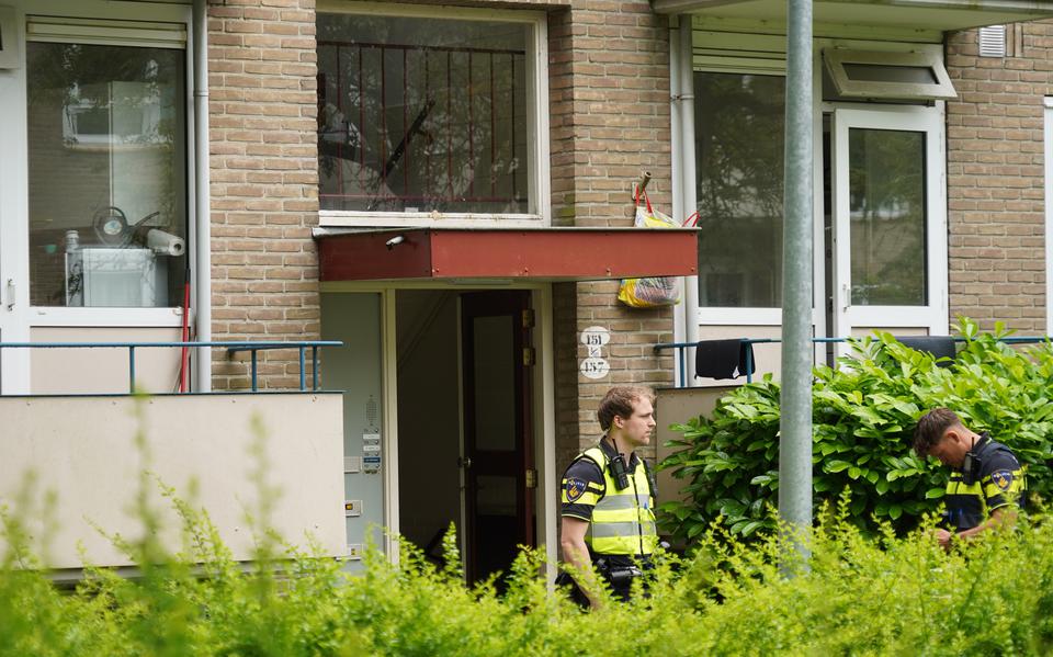 Een agent bij de portiekwoning aan de Helperzoom in Groningen, waar een vrouw (24) om het leven kwam door een politiekogel.