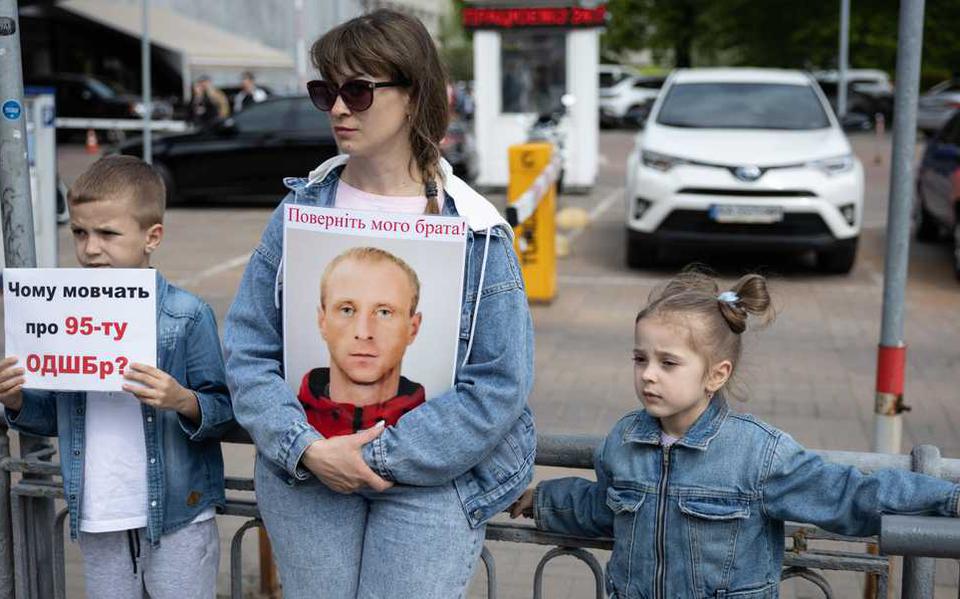 Een vrouw houdt een bordje vast met ’breng mijn broer terug’ erop in Kiev. Hij zou door de Russen in gevangenschap worden gehouden.
