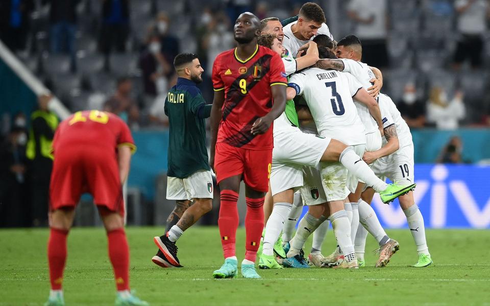 Vertwijfeling bij de Belgische spits Romelu Lukaku. Op de achtergrond vieren de Italianen feest.