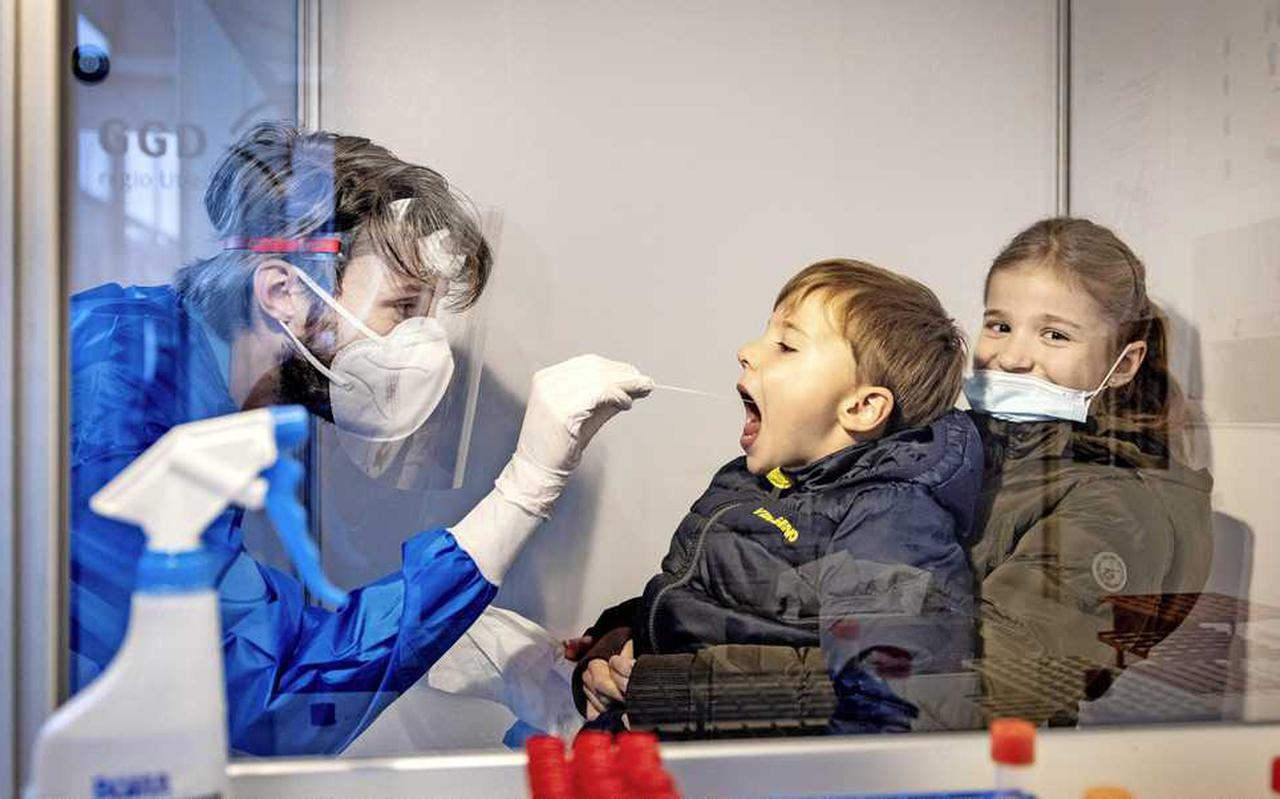 Een GGD-medewerker voert een coronatest uit bij een kind.