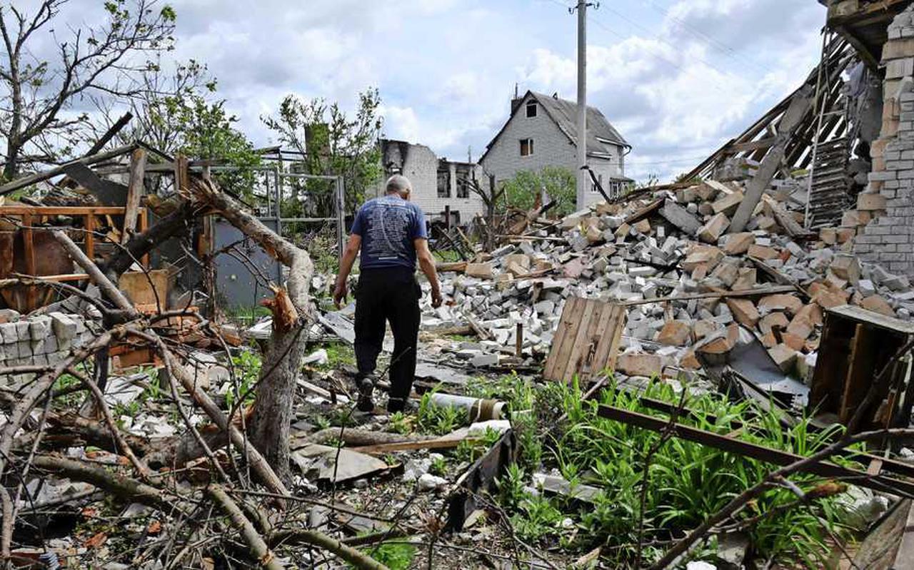 Een bewoner van het dorp Mala Rogan, ten oosten van Charkov, loopt tussen de overblijfselen van zijn verwoeste woning. 