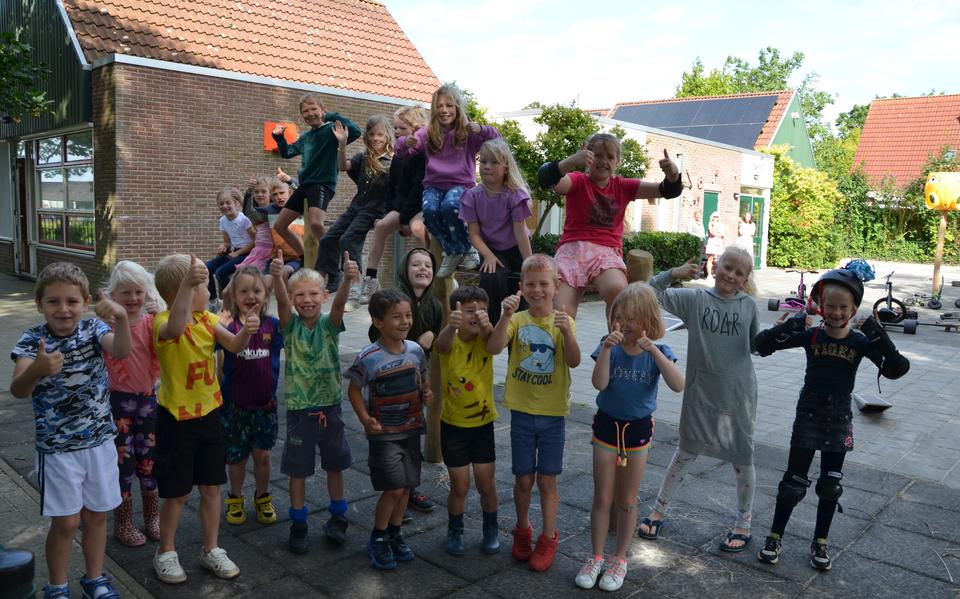 Leerlingen van De Barte in Hemelum bij het nieuwe tuimelrek dat ze vorig jaar kregen op het vernieuwde schoolplein.
