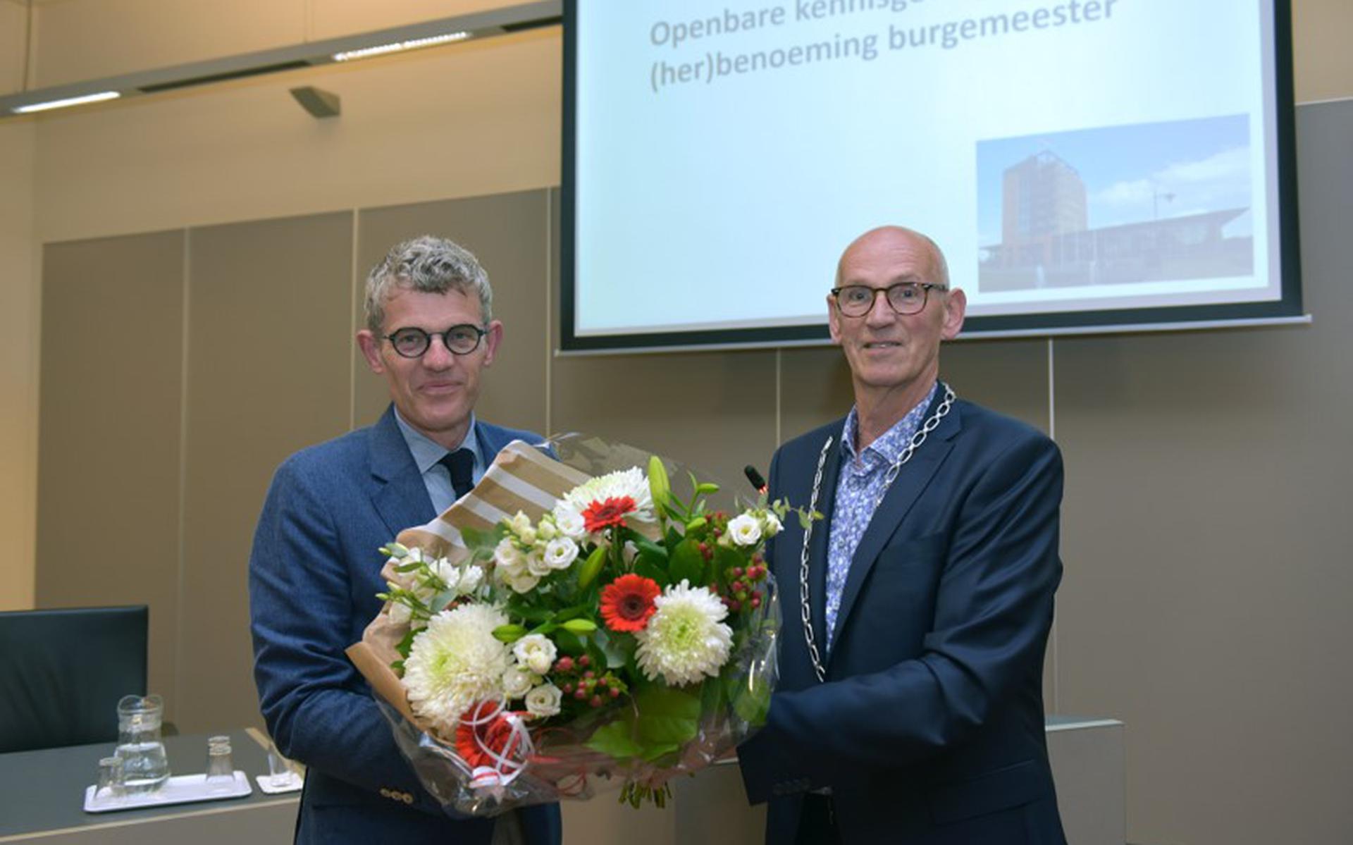Burgemeester André van de Nadort krijgt bloemen van plaatsvervangend raadsvoorzitter Ton Mulder. Foto Lenus van der Broek