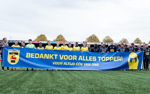 Spelers en technische staf van SC Cambuur met een spandoek voor Henk de Jong, voorafgaand aan de wedstrijd tegen FC Twente.