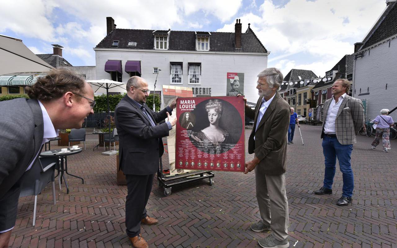 Wethouder Friso Douwstra (links) bekijkt een model van het tegeltableau dat Kris Callens en Berrn Bilker (rechts) omhoog houden.  FOTO Marchje Andringa