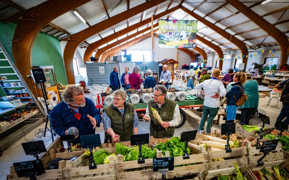 Auke Hempenius (links) met Grietje en Jelmar Lautenbach bij het vernieuwde groenteplein van boerderijwinkel Feintsje fan Menaam.