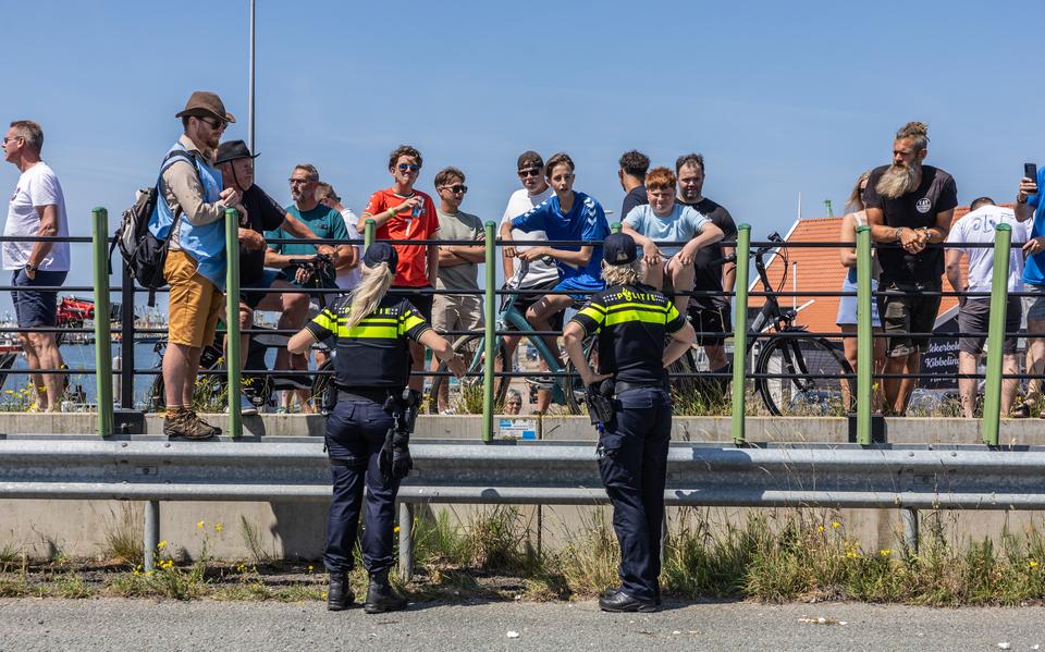 Agenten gaan in gesprek met de groep die demonstranten van Extinction Rebellion bekogelde op de Afsluitdijk. Daarbij werd ook een cameraman van Omrop Fryslân geraakt.
