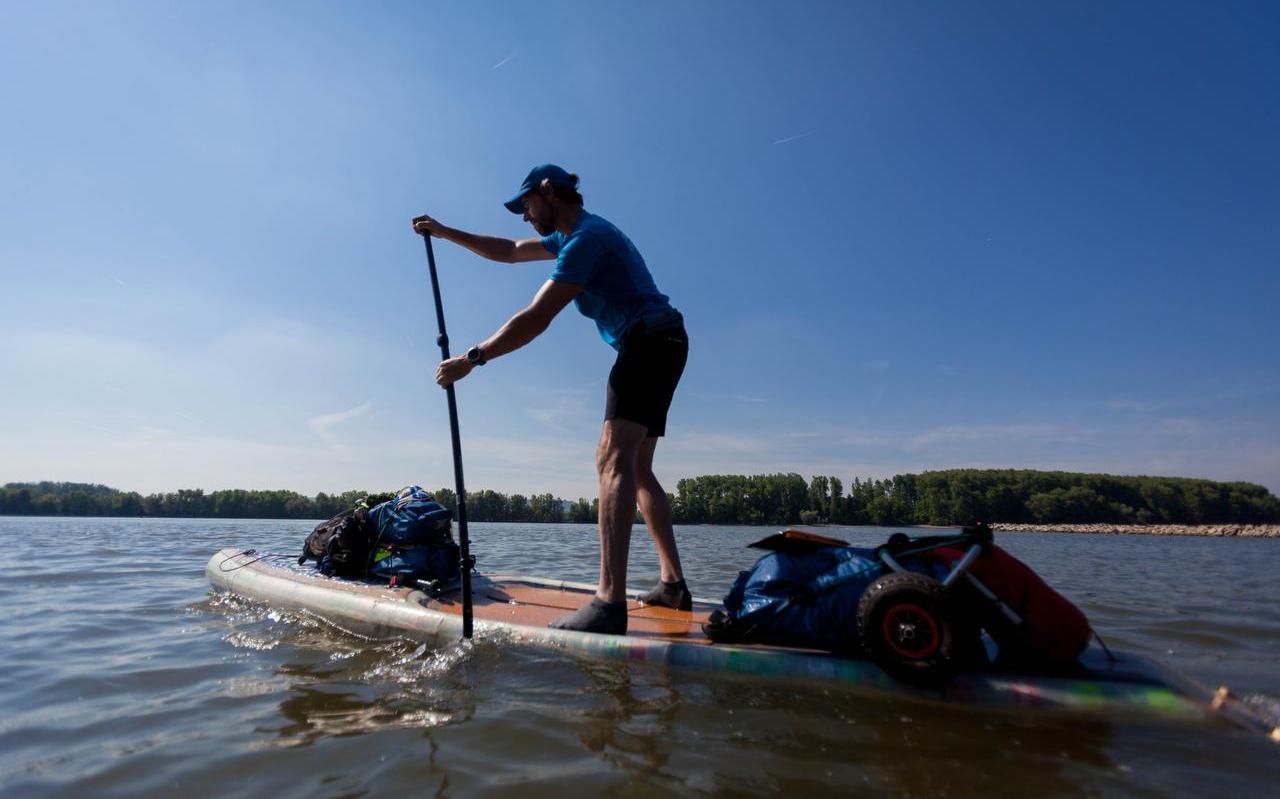 Performancekunstenaar Merijn Tinga, alias de PlasticSoupSurfer, tijdens zijn sup-tocht over de Rijn. FOTO EELKE DEKKER
Performancekunstenaar Merijn Tinga, alias de PlasticSoupSurfer, tijdens zijn sup-tocht over de Rijn. FOTO EELKE DEKKER