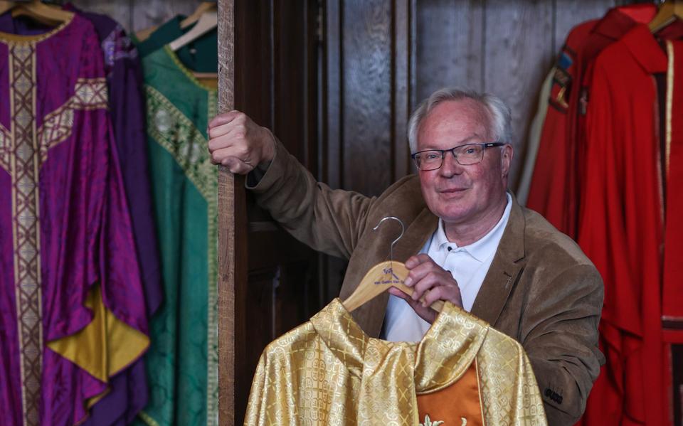 Pastoor Peter van der Weide in de sacristie van de Sint-Martinuskerk waar de vele kleuren kazuifels (priestergewaad) in houten kasten hangen. Dit goudkleurige exemplaar kreeg hij ooit van zijn moeder.