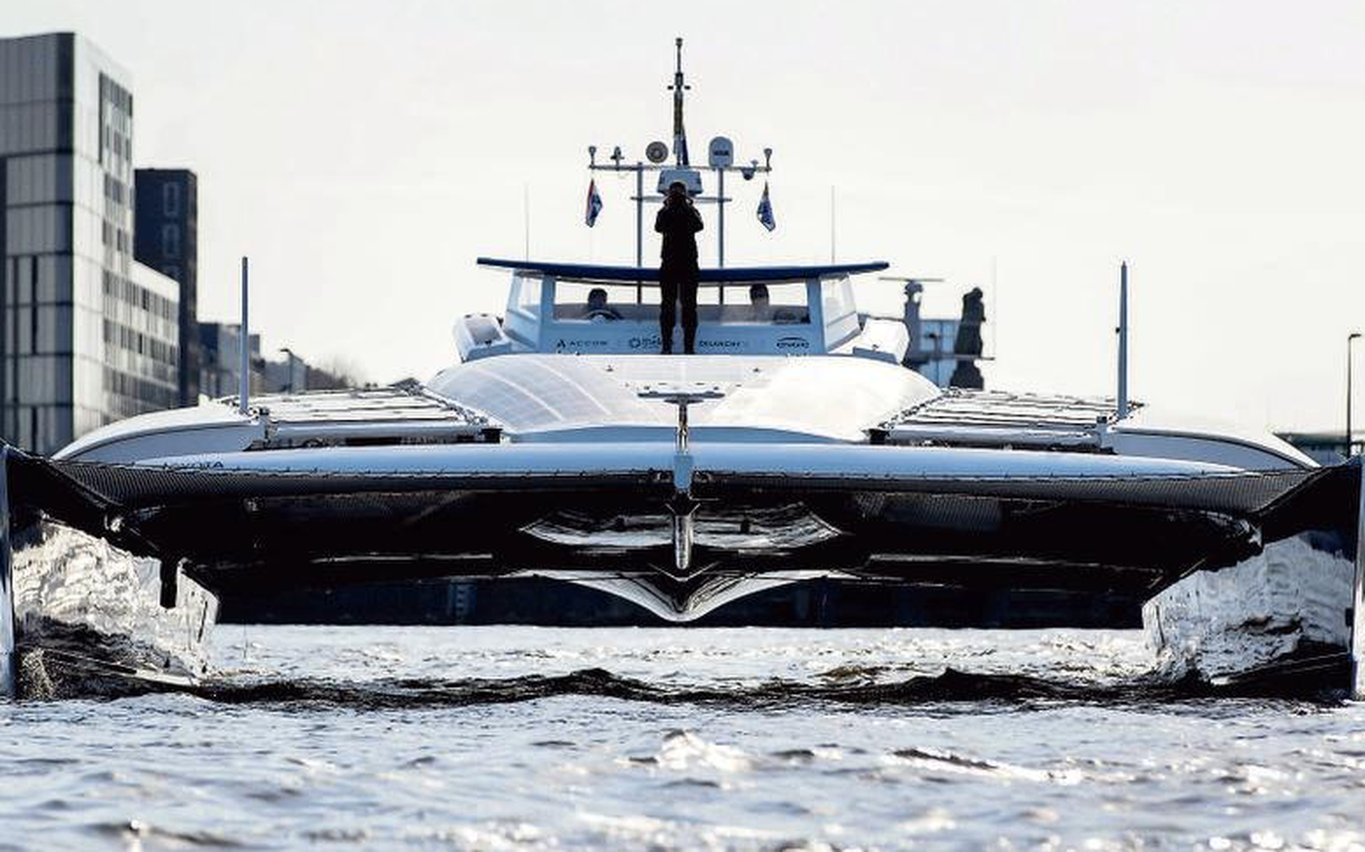 De Energy Observer voer op 5 april binnen in Amsterdam. Ondertussen is de catamaran voorzien van twee 12 meter hoge windvleugels. FOTO EPA