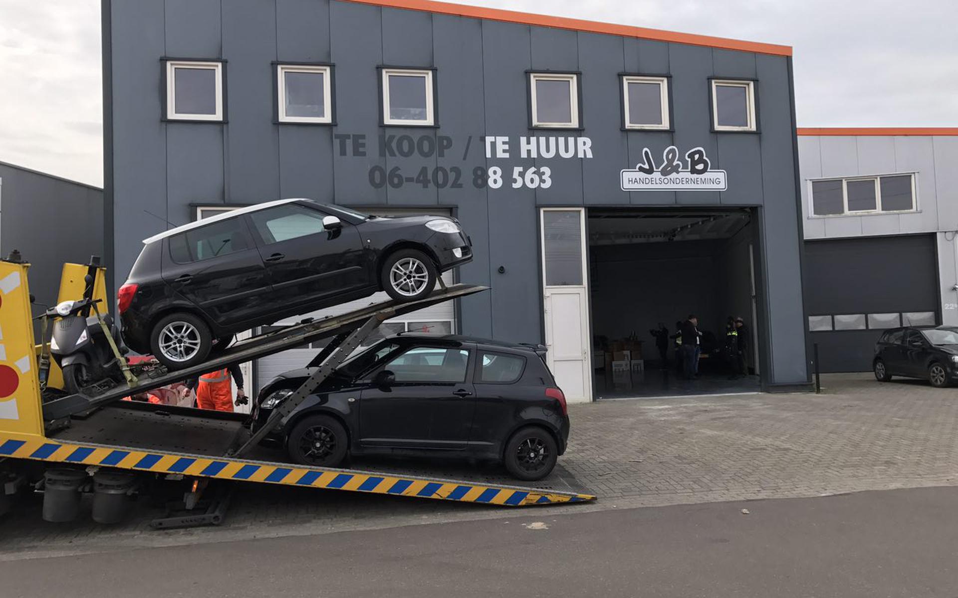 Bij een bedrijfspand aan de Apolloweg in Leeuwarden worden auto's in beslag genomen. 