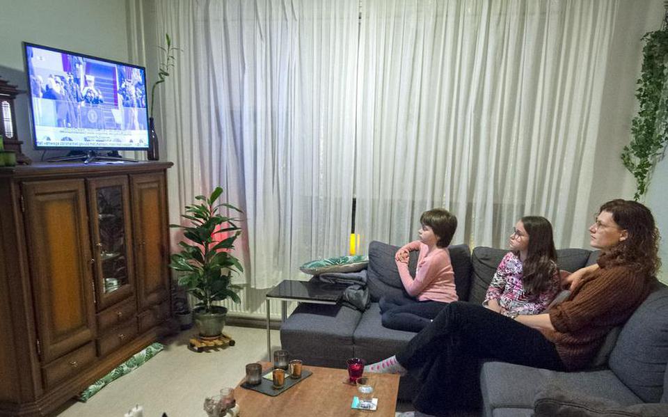 Marijke Krijgsman kijkt met haar dochters Melissa (roze trui) en Mara naar de inauguratie op tv.
