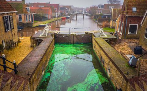 In Hindeloopen zijn het water in de sluis en de kaden in de haven groen gekleurd.
