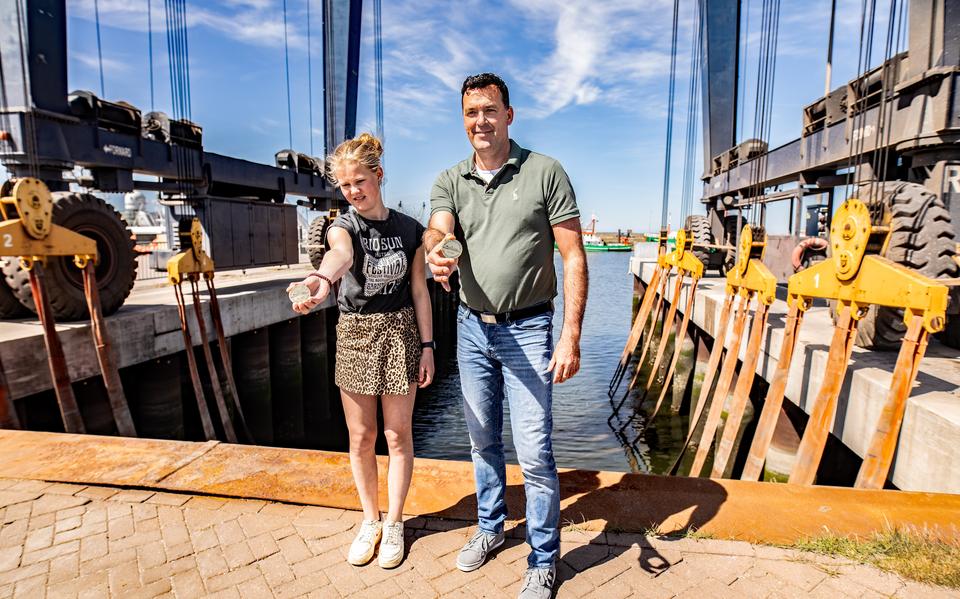 Marin Visser (l) en Arjan Iemhoff brachten een munt aan op de nieuwe snelboot voor Ameland. 