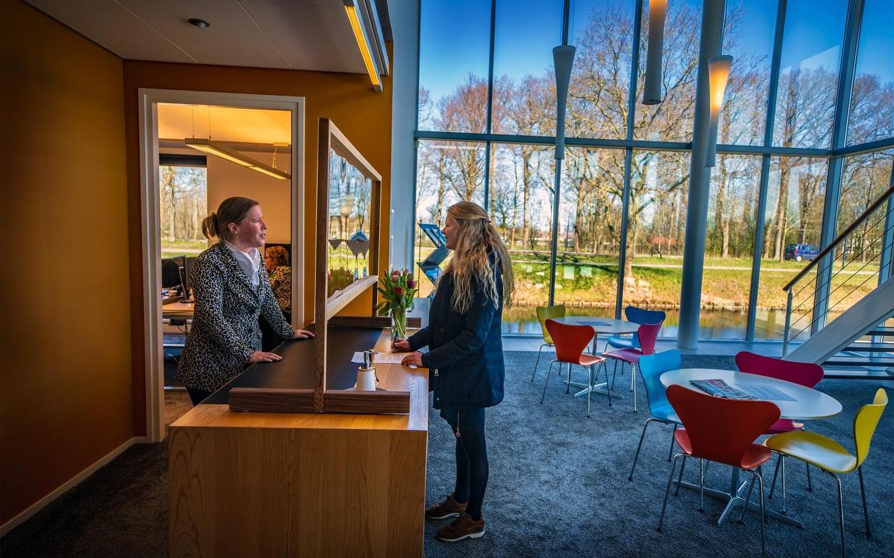 Notaris Heidi Harmsma staat achter een scherm van plexiglas een klant te woord om coronabesmetting te vermijden. Notaris Heidi Harmsma staat achter een scherm van plexiglas een klant te woord om coronabesmetting te vermijden.