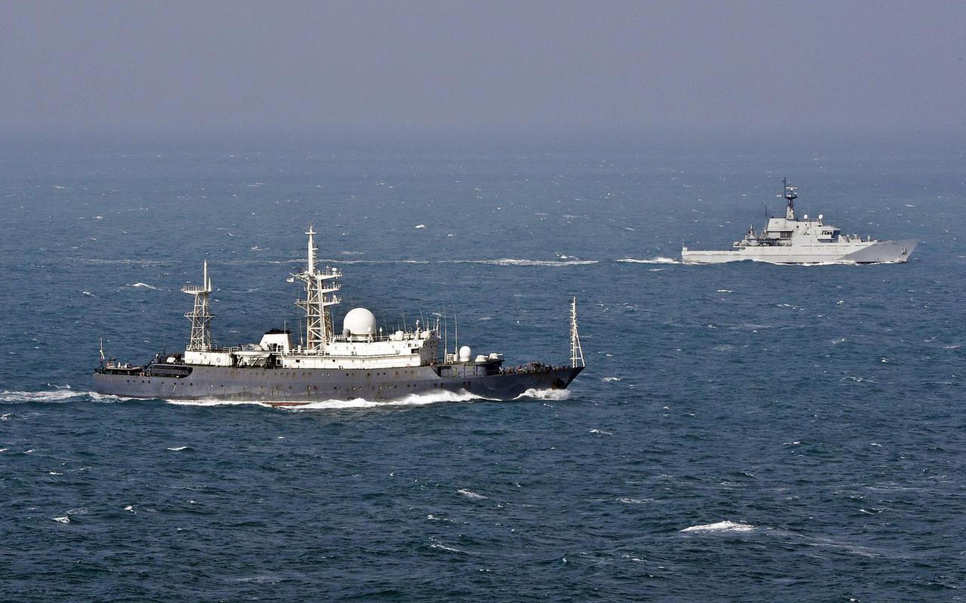 Het Russische spionageschip ‘Fjodor Golovin’ (voor) wordt begeleid door een Brits schip, donderdag in Het Kanaal. FOTO EPA
