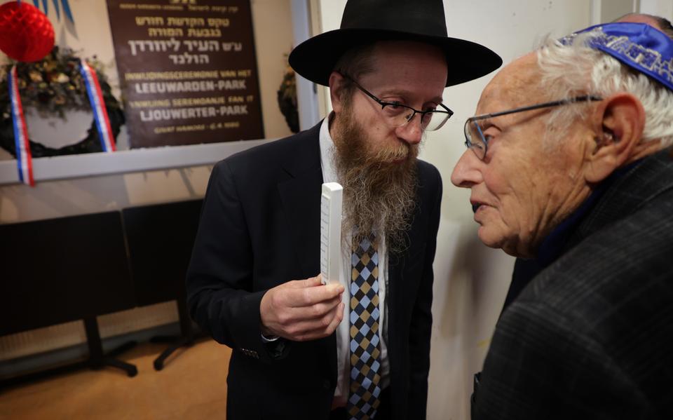 Rabijn Shmuel Spiero geeft de mezoeza aan Holocaust-overlevende Benno Troostwijk om de school in Leeuwarden in te wijden.