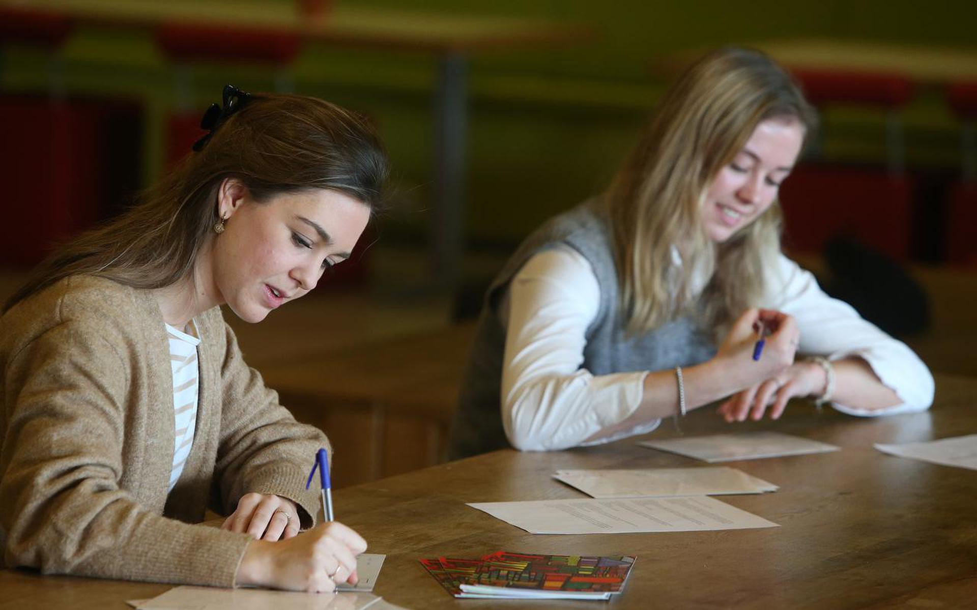 Studenten Pauline (links) en Lotte schrijven de ene na de andere kaart vol. 