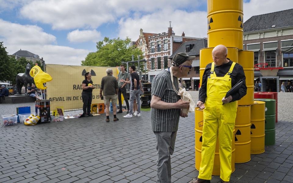 Tjeerd Palstra (met gele overal) legt bij de Waag in Leeuwarden uit waarom hij tegen kernenergie is.