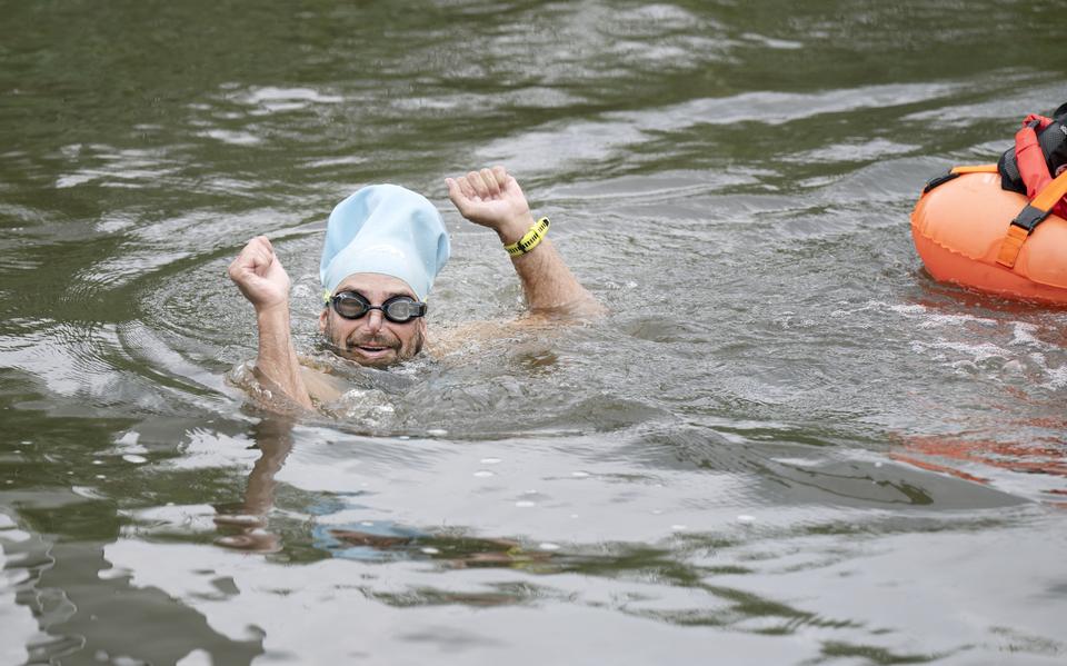 Eltjo Bazen finisht zaterdagmiddag het zwemdeel van zijn Elfstedentriatlon bij de Bonkefeart in Leeuwarden.