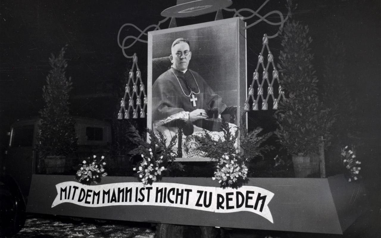 Afbeelding van Kardinaal de Jong op een praalwagen kort na de oorlog met als tekst: ‘Mit dem Mann ist nicht zu reden’.