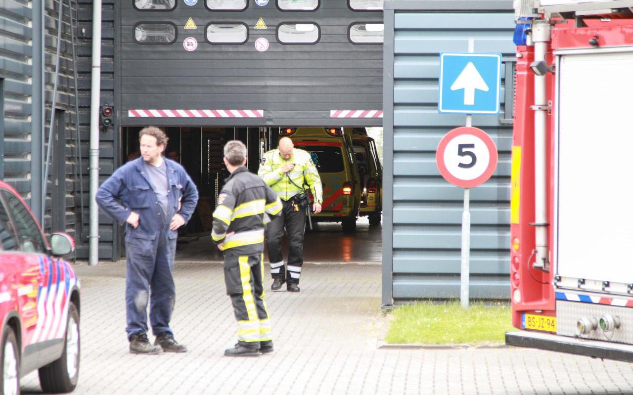 Een werknemer en hulpverleners bij de ingang van Douna Machinery in Leeuwarden op de dag van het fatale ongeval, 17 mei 2018. FOTO ANTON KAPPERS