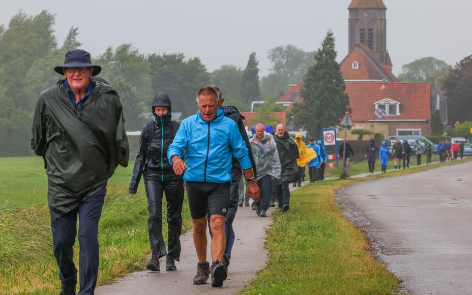 Doorkomst van de eerste wandelaars bij Easterwierrum als ze er 13,5 kilometer wind en regen op hebben zitten. 