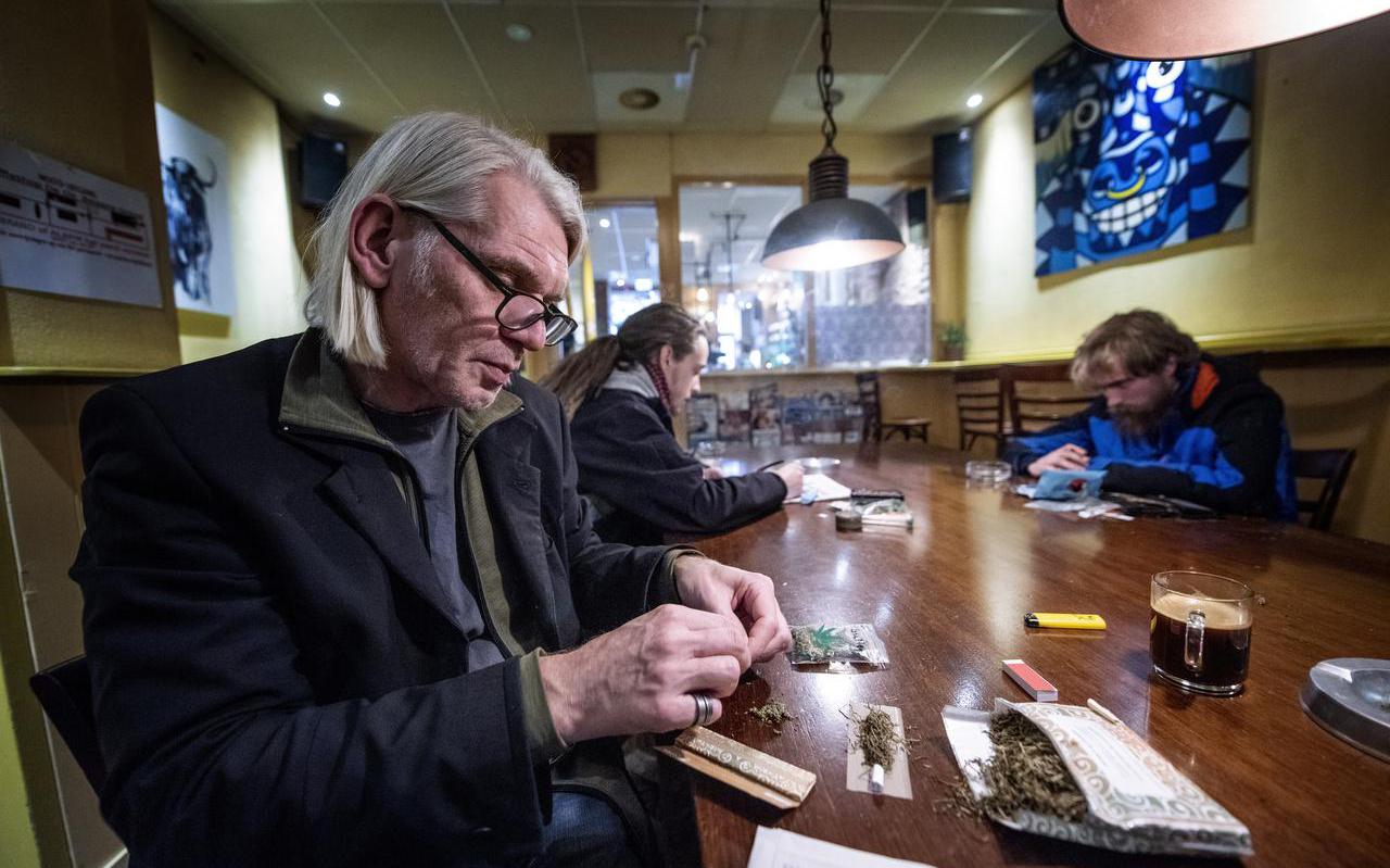 Gerrit Jan ten Bloemendal van coffeeshop De Os draait een joint met kruiden en stuff. ,,Het draait een stuk lastiger dan tabak.” FOTO HOGE NOORDEN/JACOB VAN ESSEN