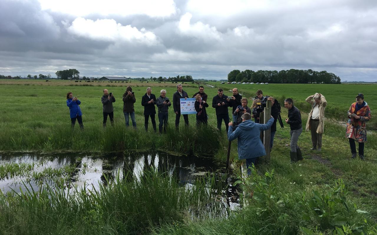 Boer Sjoerd Miedema haalt de peilbuis omhoog om zijn veenland nog natter te maken. Helemaal rechts: Urgenda-directeur Marjan Minnesma. FOTO LC Boer Sjoerd Miedema haalt de peilbuis omhoog om zijn veenland nog natter te maken. Helemaal rechts: Urgenda-directeur Marjan Minnesma. FOTO LC