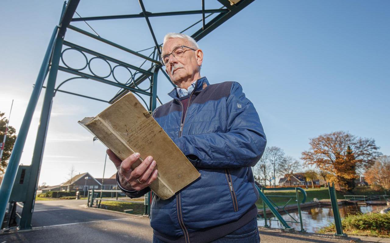 Reitze Jonkman bladert door het Uitgavenboek, op de brug over de vaart in Appelscha. Reitze Jonkman bladert door het Uitgavenboek, op de brug over de vaart in Appelscha.