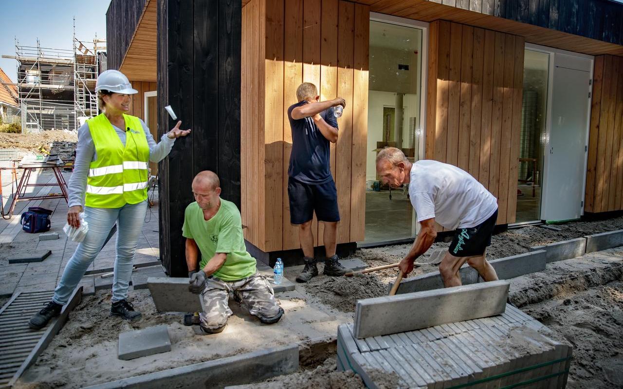 FNV-consulente Rita Minnes deelt water uit aan bouwvakkers in de nieuwbouwwijk Houkepoort in Sneek. FOTO NIELS DE VRIES FNV-consulente Rita Minnes deelt water uit aan bouwvakkers in de nieuwbouwwijk Houkepoort in Sneek. FOTO NIELS DE VRIES