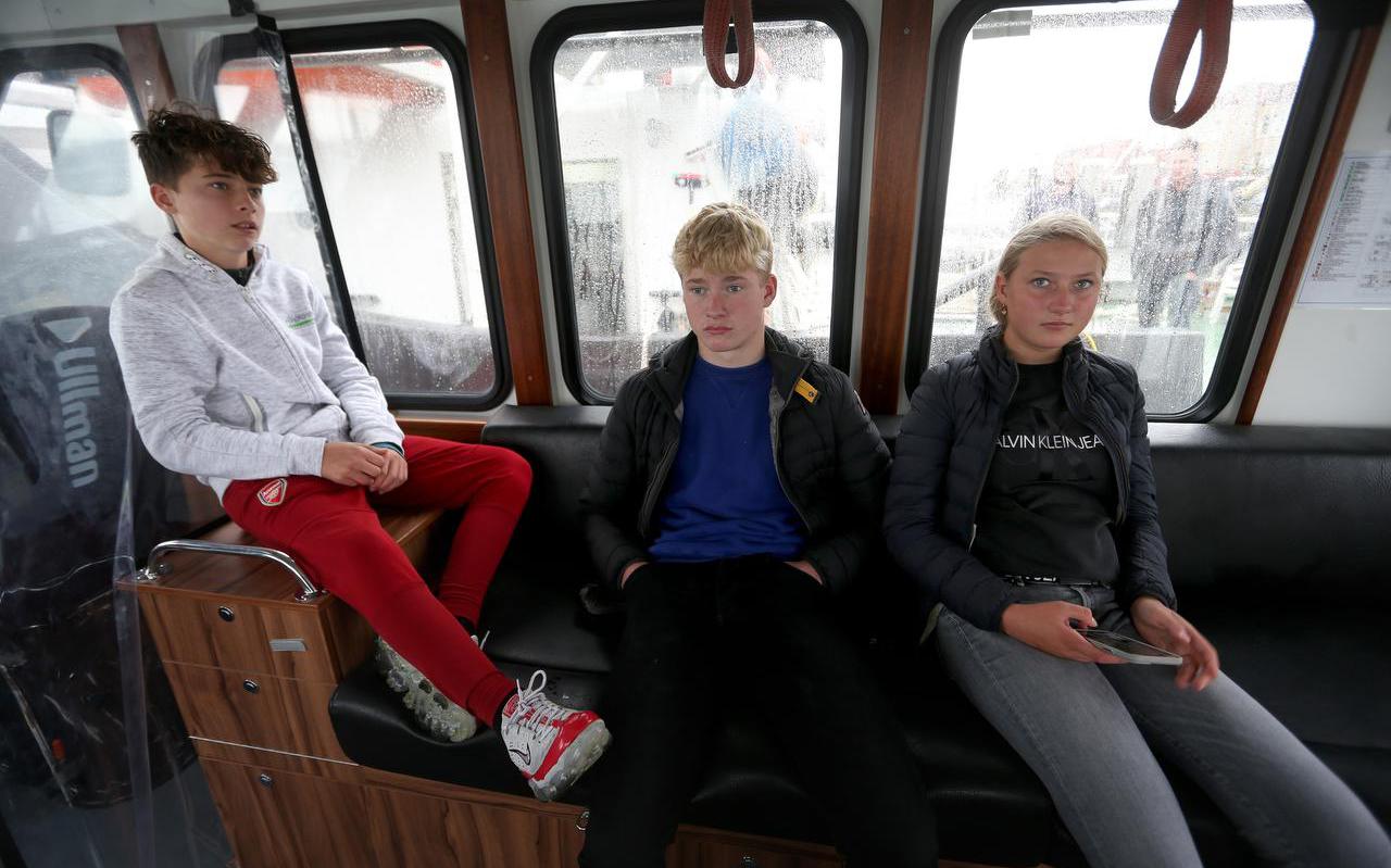 Etienne François, Micha Koning en Fleur Geertzen op het veerbootje dat hen ’s morgens van Vlieland naar Terschelling brengt en ’s middags weer terug.