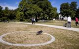 Cirkels die door de gemeente in de ligweides van Het Park in Rotterdam zijn aangebracht. Bezoekers worden gevraagd plaats te nemen in de cirkels. De gemeente hoopt op deze manier de 1,5 meter afstand te kunnen waarborgen. FOTO ANP KOEN VAN WEEL