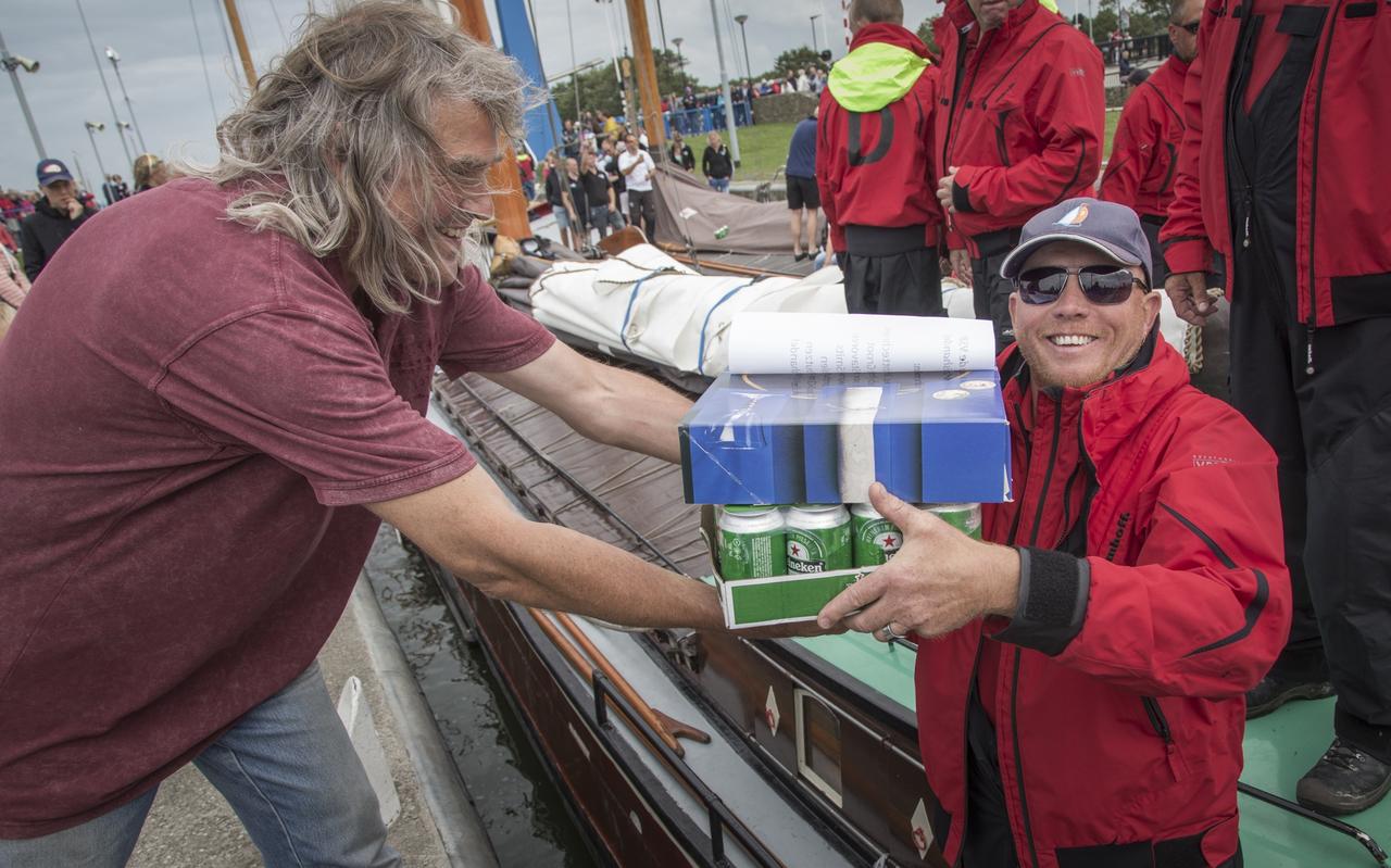 De Zeeuw Hilaire Risseeuw overhandigt schipper Jeroen Pietersma van het Drachtster skûtsje de harinkjes van Doede. FOTO TOM COEHOORN De Zeeuw Hilaire Risseeuw overhandigt schipper Jeroen Pietersma van het Drachtster skûtsje de harinkjes van Doede. FOTO TOM COEHOORN