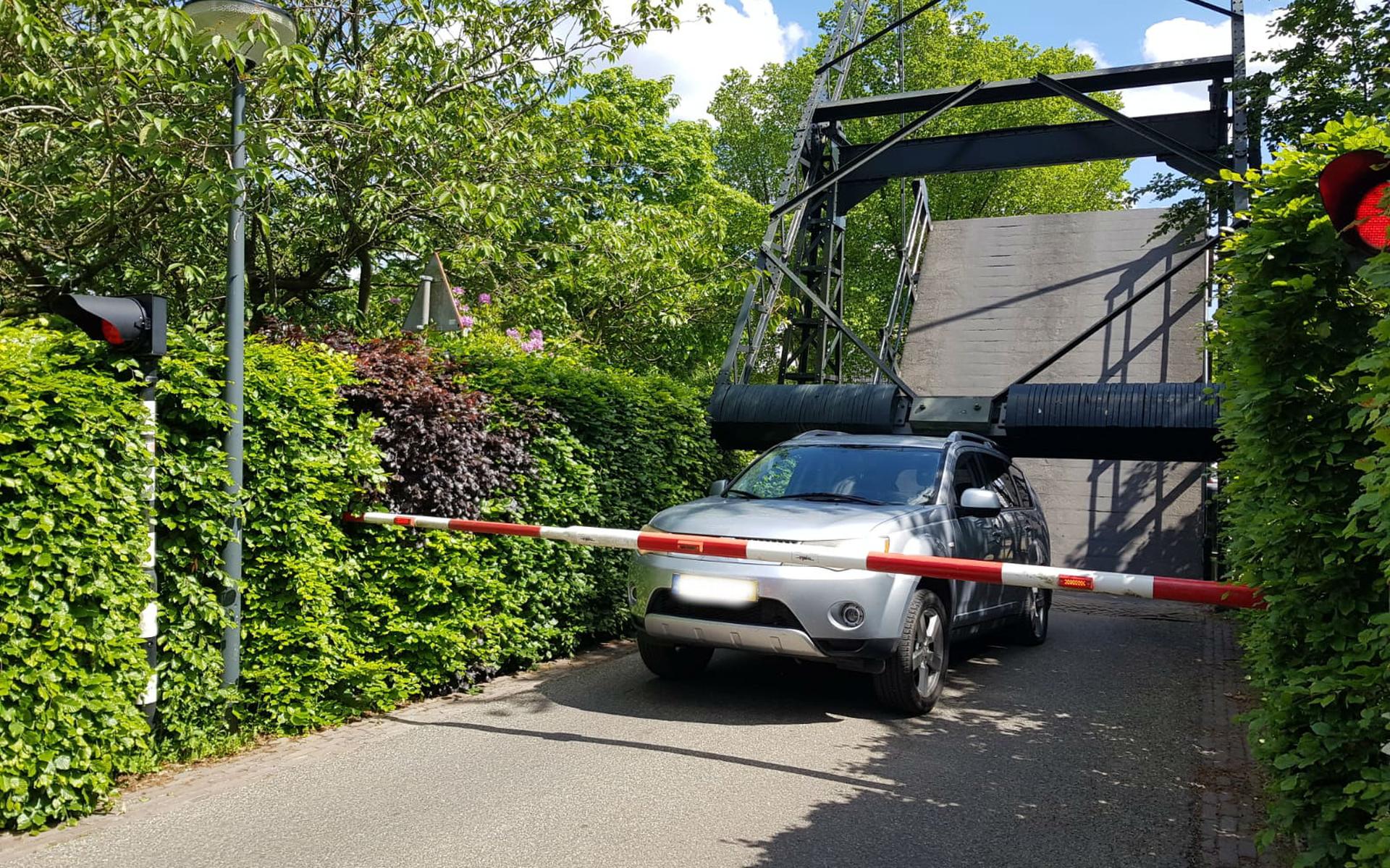 Oeps: automobiliste mist rood licht en staat vast tussen slagboom en brug - Leeuwarder Courant
