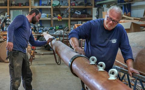 Mastenmaker Piet Blaauw legt met zijn zoon Romke de laatste hand aan een nieuwe giek bij hun scheepstimmerbedrijf in Stavoren. 