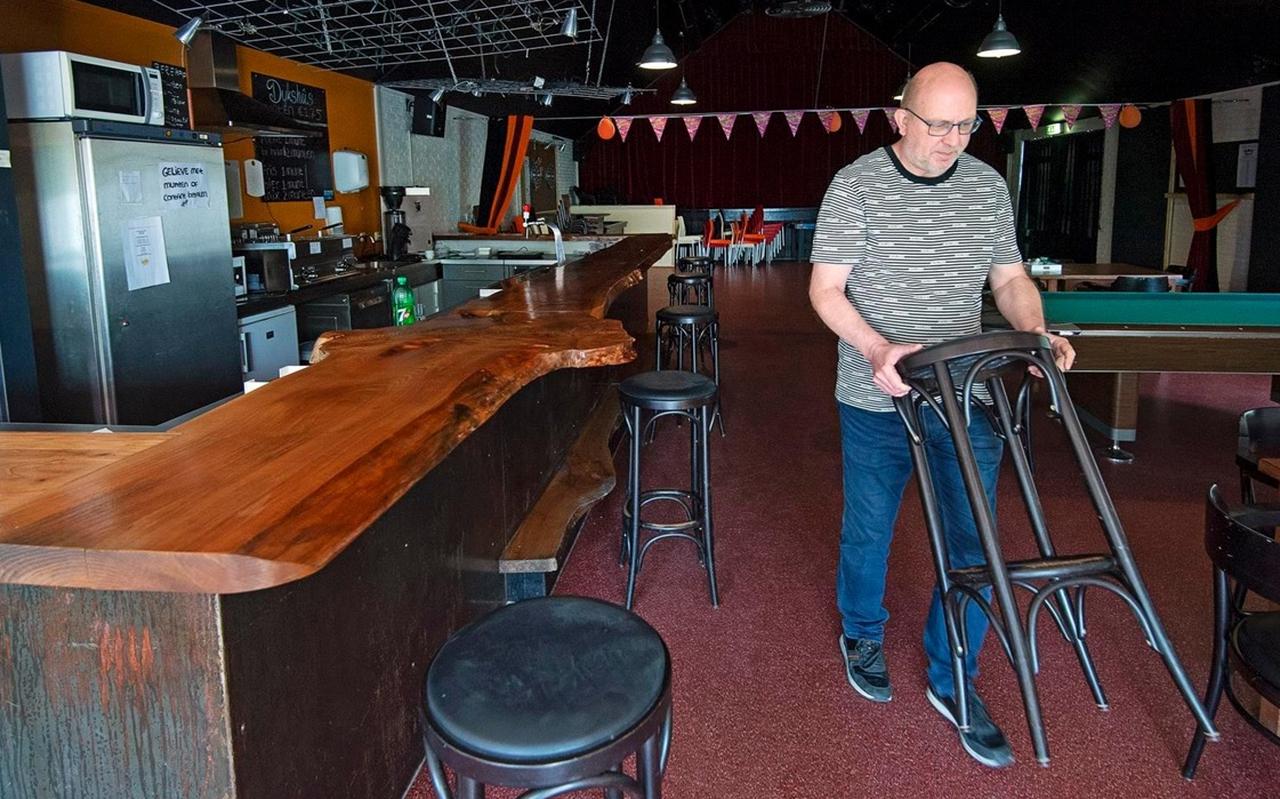 Yko Miedema van dorpshuis It Dykshûs in Engwierum verwijdert barkrukken zodat aan de tap voldoende afstand ontstaat. FOTO MARCEL VAN KAMMEN Yko Miedema van dorpshuis It Dykshûs in Engwierum verwijdert barkrukken zodat aan de tap voldoende afstand ontstaat. FOTO MARCEL VAN KAMMEN
