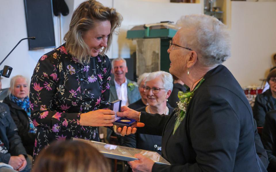 Wethouder Petra van den Akker reikt de Penning van Verdienste uit aan Anny Gietema, voorzitter van het koor. 