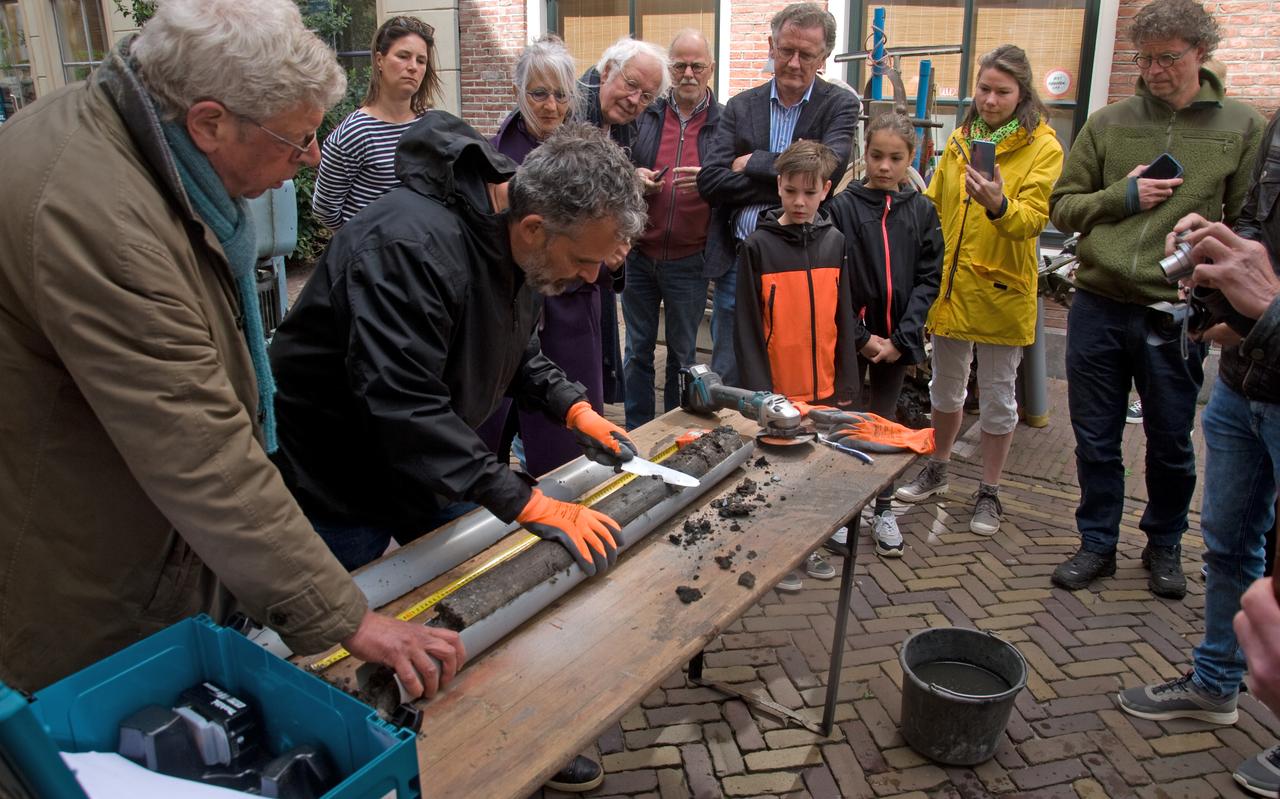 Behoedzaam en onder grote belangstelling opent archeoloog Jan-Willem Oudhof een van de buizen met terpaarde. Behoedzaam en onder grote belangstelling opent archeoloog Jan-Willem Oudhof een van de buizen met terpaarde.