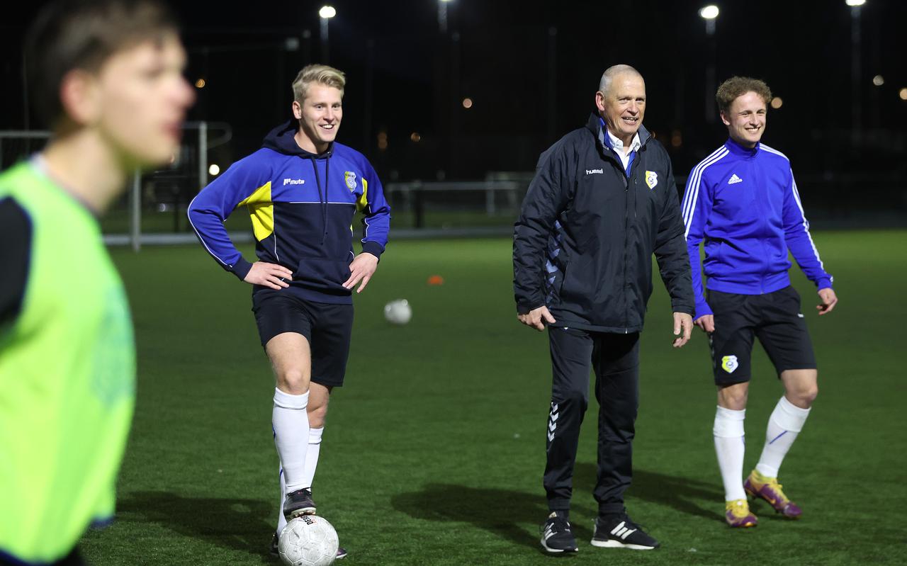 Jan Stuiver (midden) kijkt op het veld van Leovardia samen met Johan Kolk (links) en Theo Molenaar toe bij de training van Geel Wit onder-19..