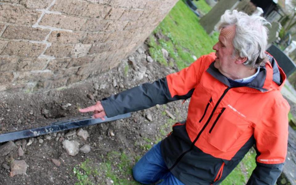 Joute Bouma is een van de teleurgestelde vrijwilligers in Hegebeintum die ziet hoe bliksemafleiders uit muren zijn gerukt en koperen buizen voor regenafvoer van de dakgoten zijn gesloopt. Op de foto wijst hij op de gloednieuwe led-verlichting die voorlopig niet meer kan worden gebruikt.