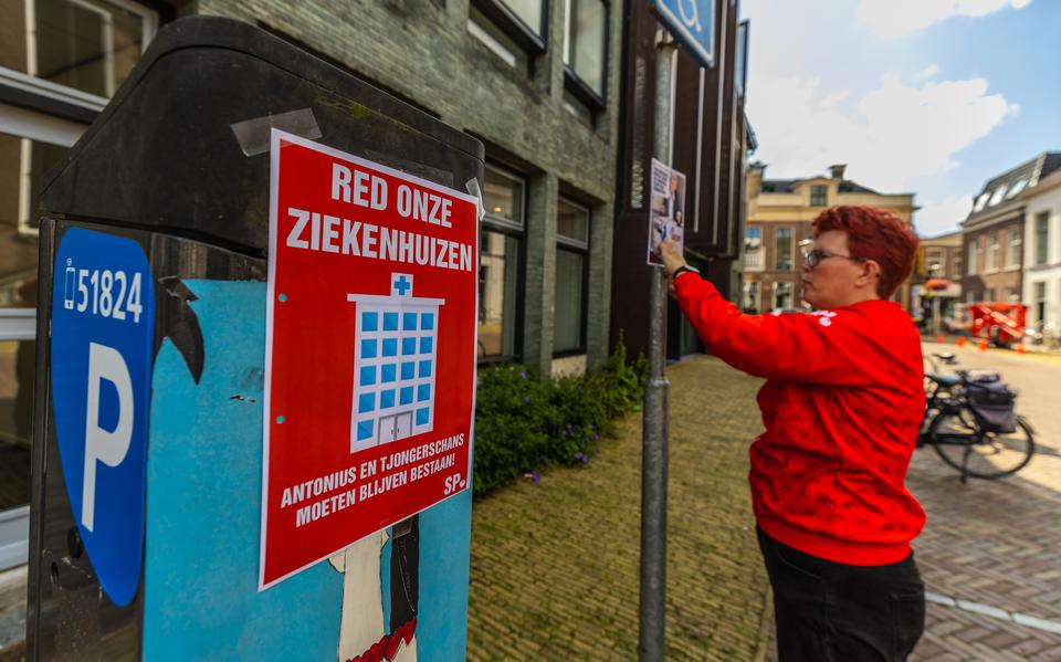 SP-Statenlid Hanneke Goede plakt in juli affiches tegen de sluiting van het ziekenhuis in Sneek. 